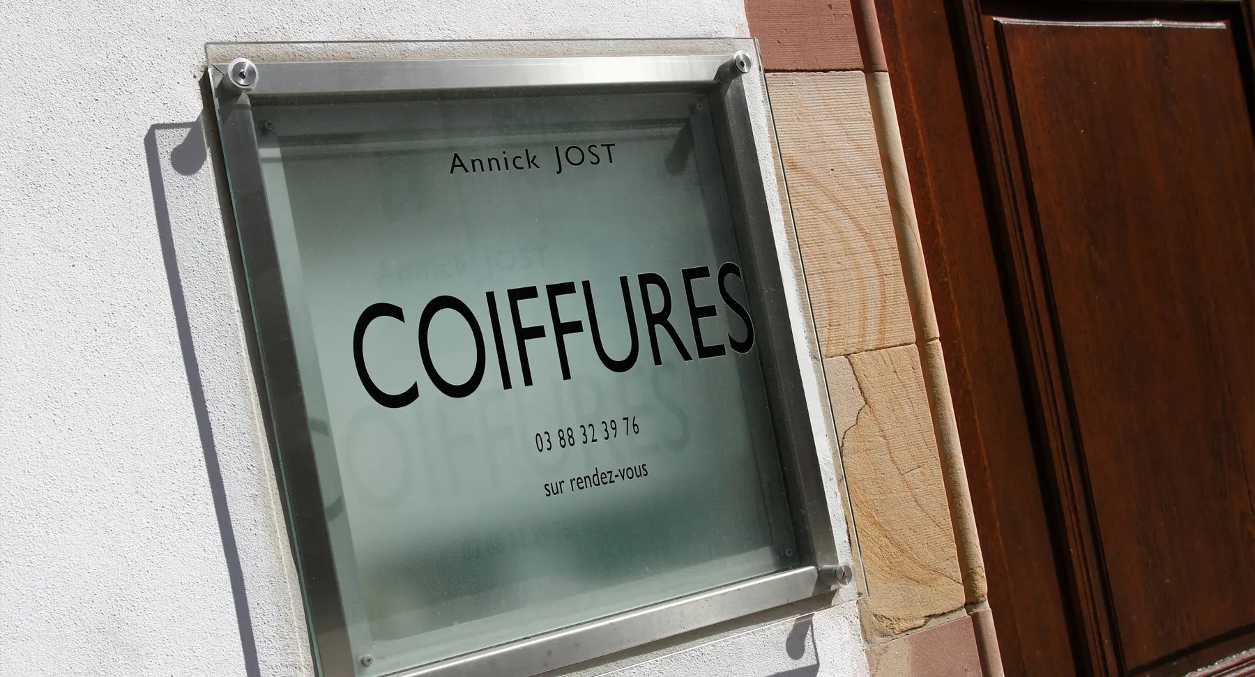 La plaque du salon : Annick Jost, Coiffures, sur rendez-vous