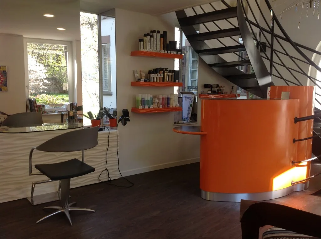 Le comptoir orange et l'escalier en colimaçon du salon